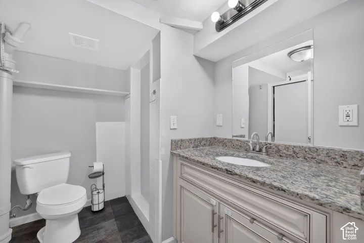 Vanity with a light-colored stone countertop, undermount sink, and brushed nickel faucet