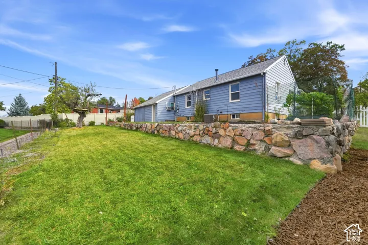 Expansive lawn area with a stone retaining wall and partial white picket fencing