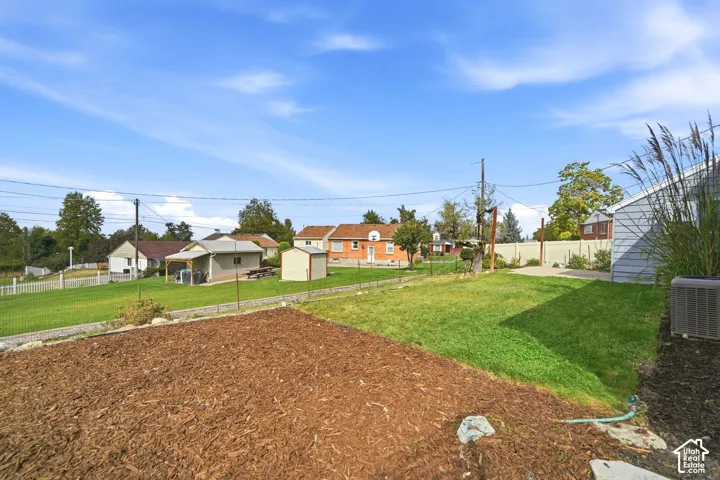 Expansive grassy yard with a dedicated mulched area and fencing