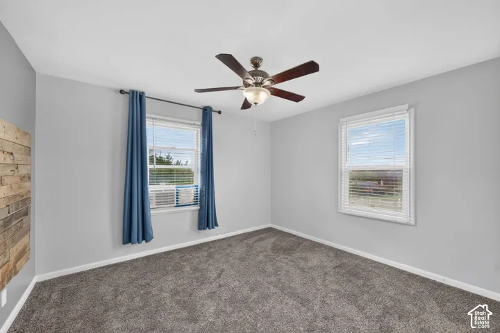 Spacious room featuring neutral grey walls and plush grey carpeting