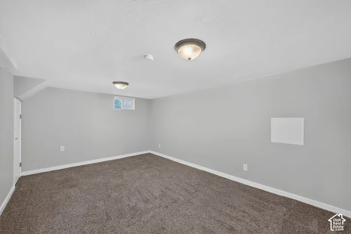 Neutral gray wall paint, textured ceiling, flush-mount ceiling lighting, window, and wall-to-wall carpeting