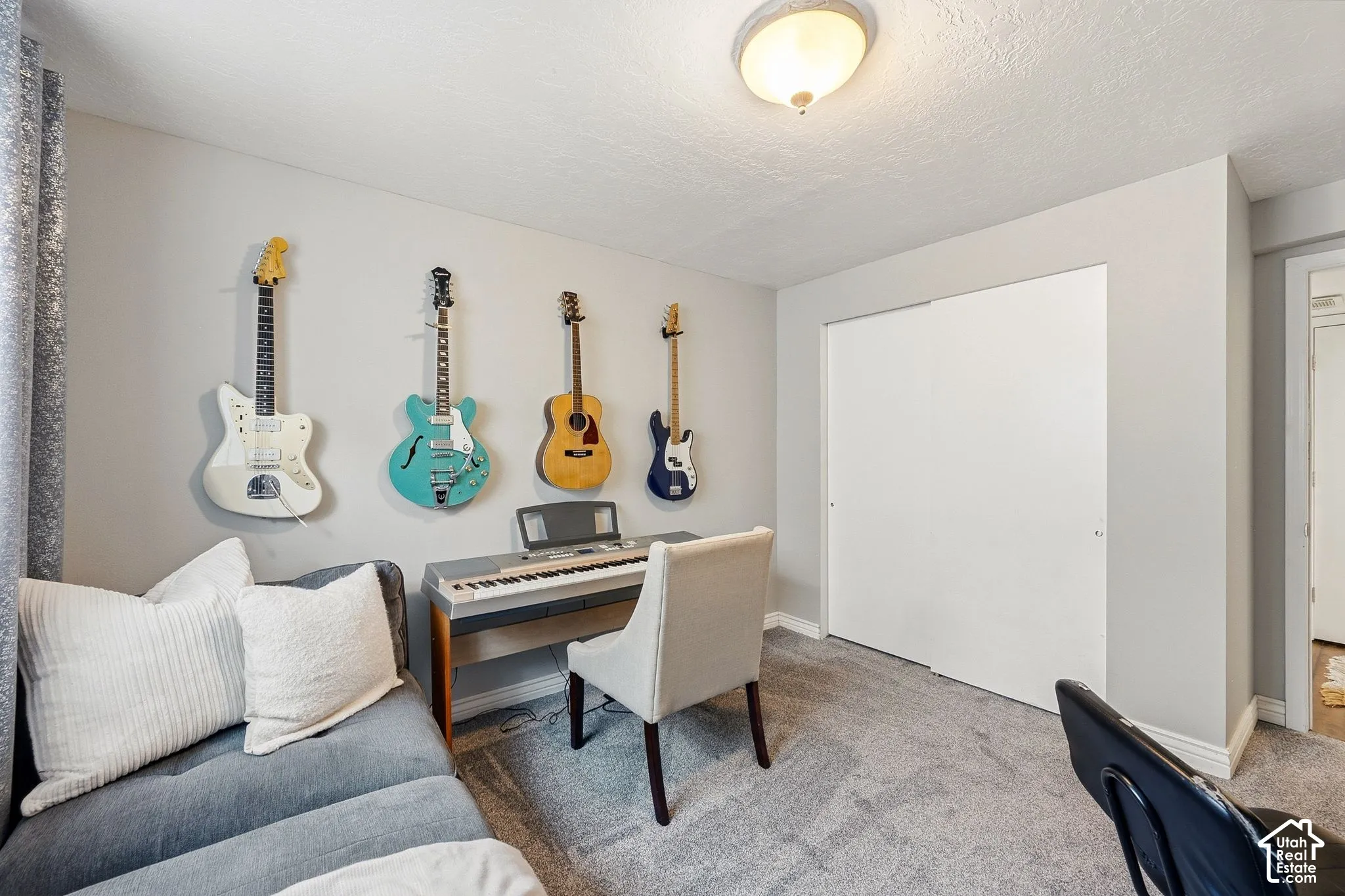 Wall-to-wall carpeting with light gray walls, featuring a sliding closet door and a ceiling-mounted light fixture