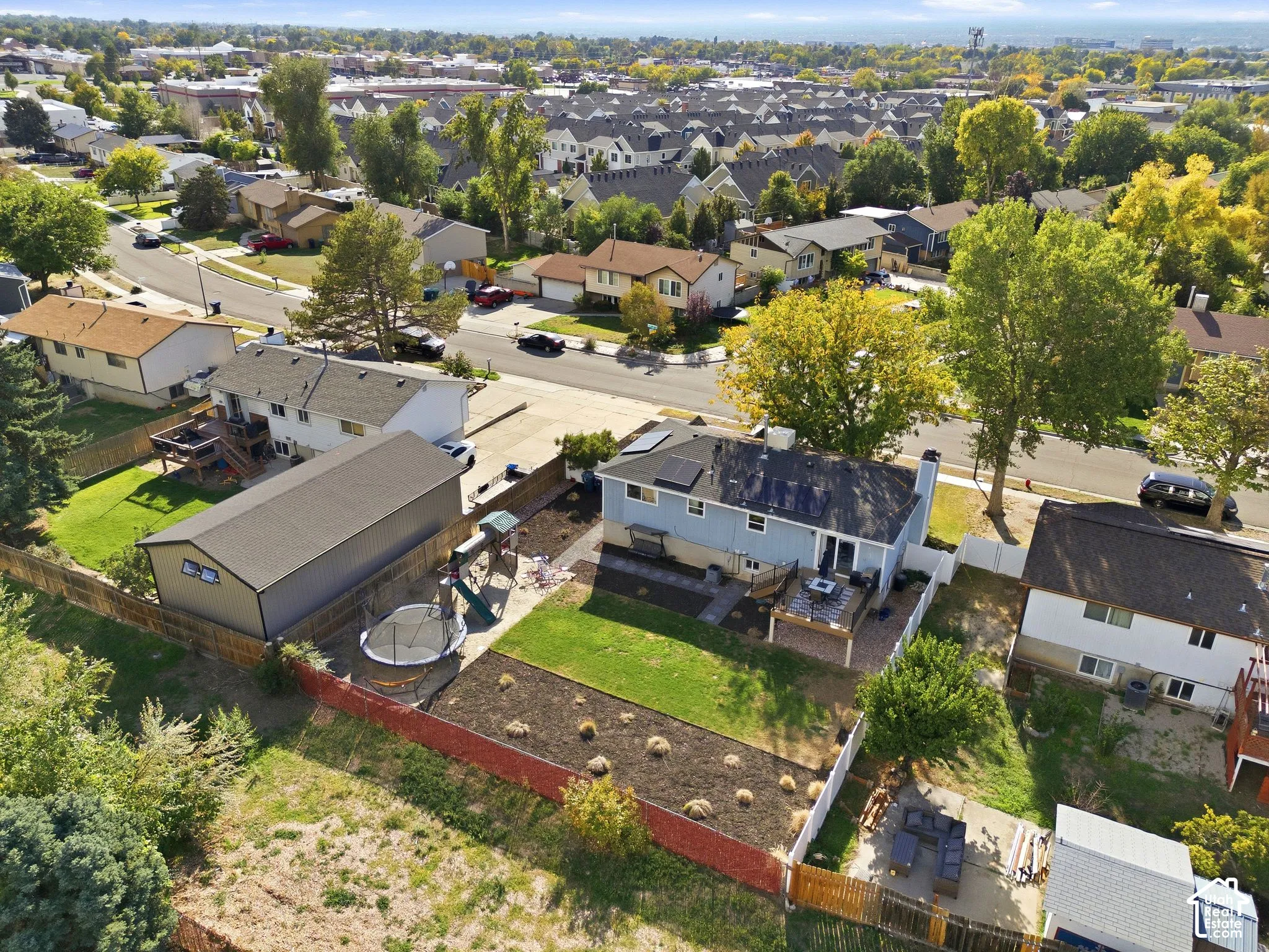 Expansive backyard featuring a manicured lawn, established landscaping, and a fenced perimeter