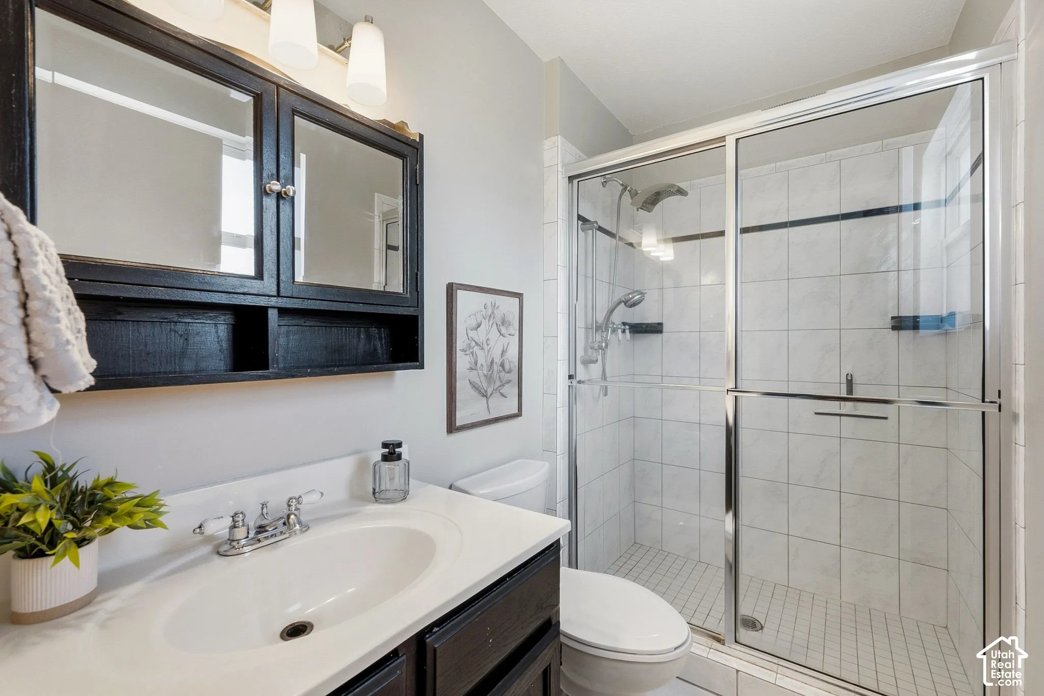 White vanity with integrated sink, chrome faucet, and dark wood-finish cabinetry
