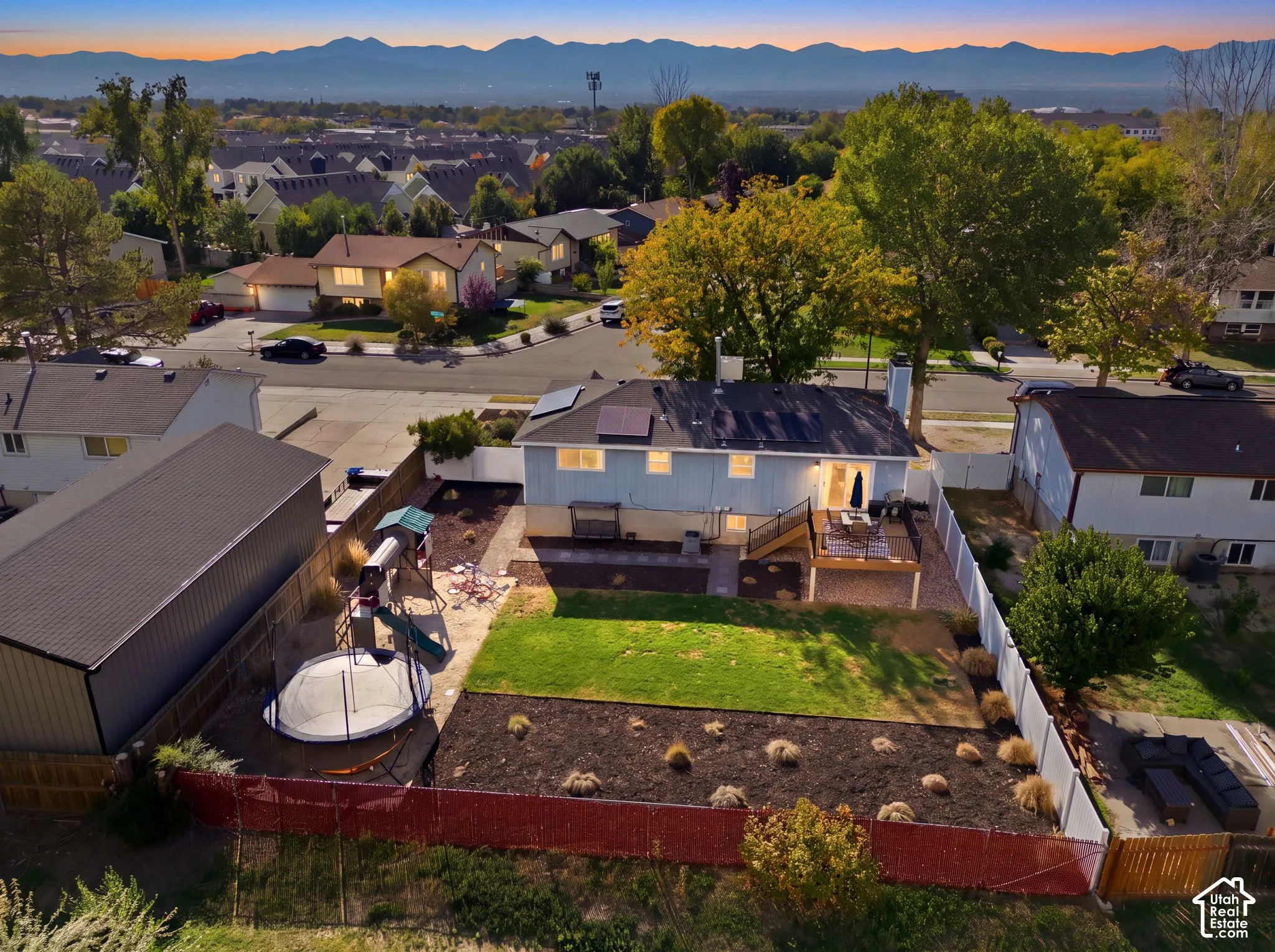 Expansive backyard featuring a manicured lawn, established landscaping, and a multi-level deck