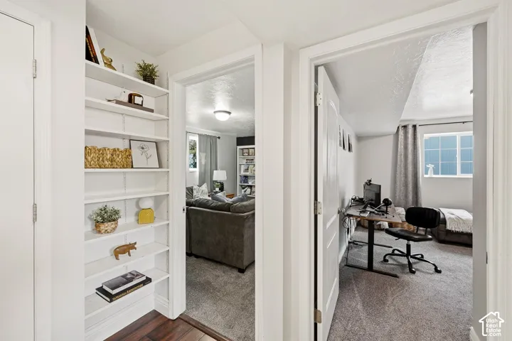 Hallway with built-in shelving, wood-finish flooring, and recessed lighting