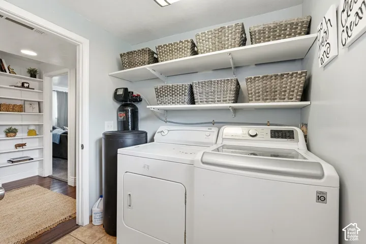 Laundry area featuring a top-load washing machine, front-load dryer, and wall-mounted shelving