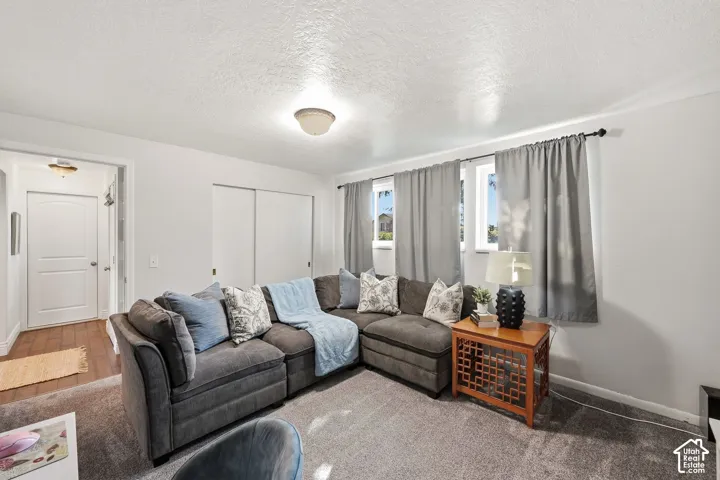 White walls complement the grey carpet flooring and recessed lighting