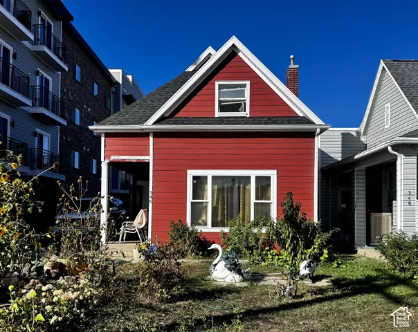 Red exterior hardie plank siding with white trim, dark shingle roof, and covered porch