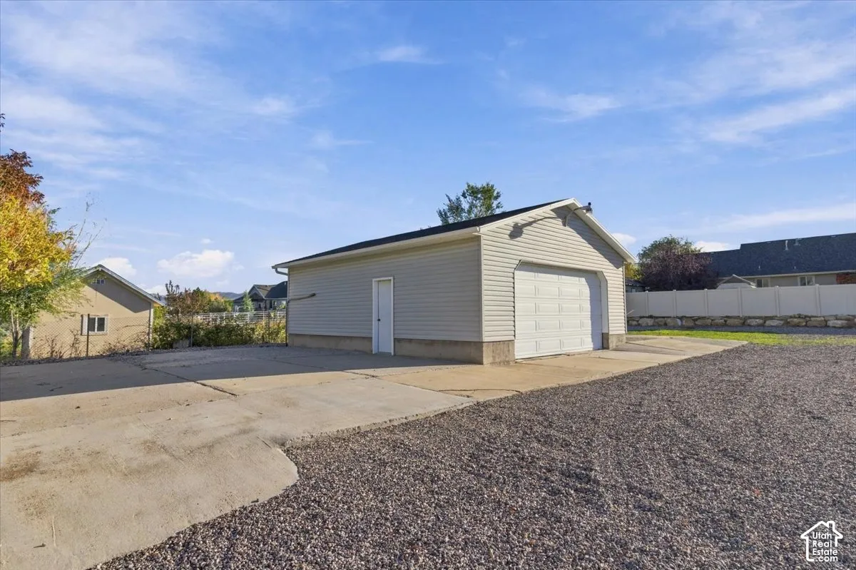 Detached garage with horizontal siding, a roll-up door, and a dedicated entry door