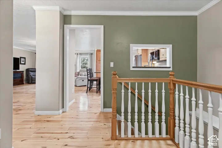 Wood-finish flooring throughout, with crown molding, and a built-in kitchen pass-through window
