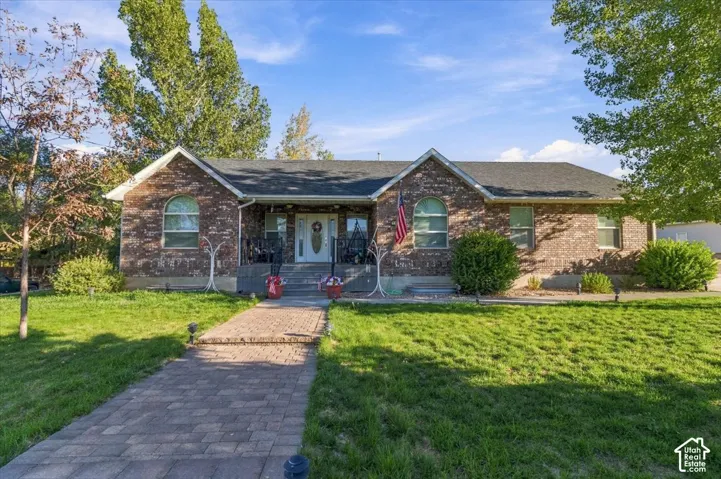Brick exterior with a dark shingle roof and a concrete porch