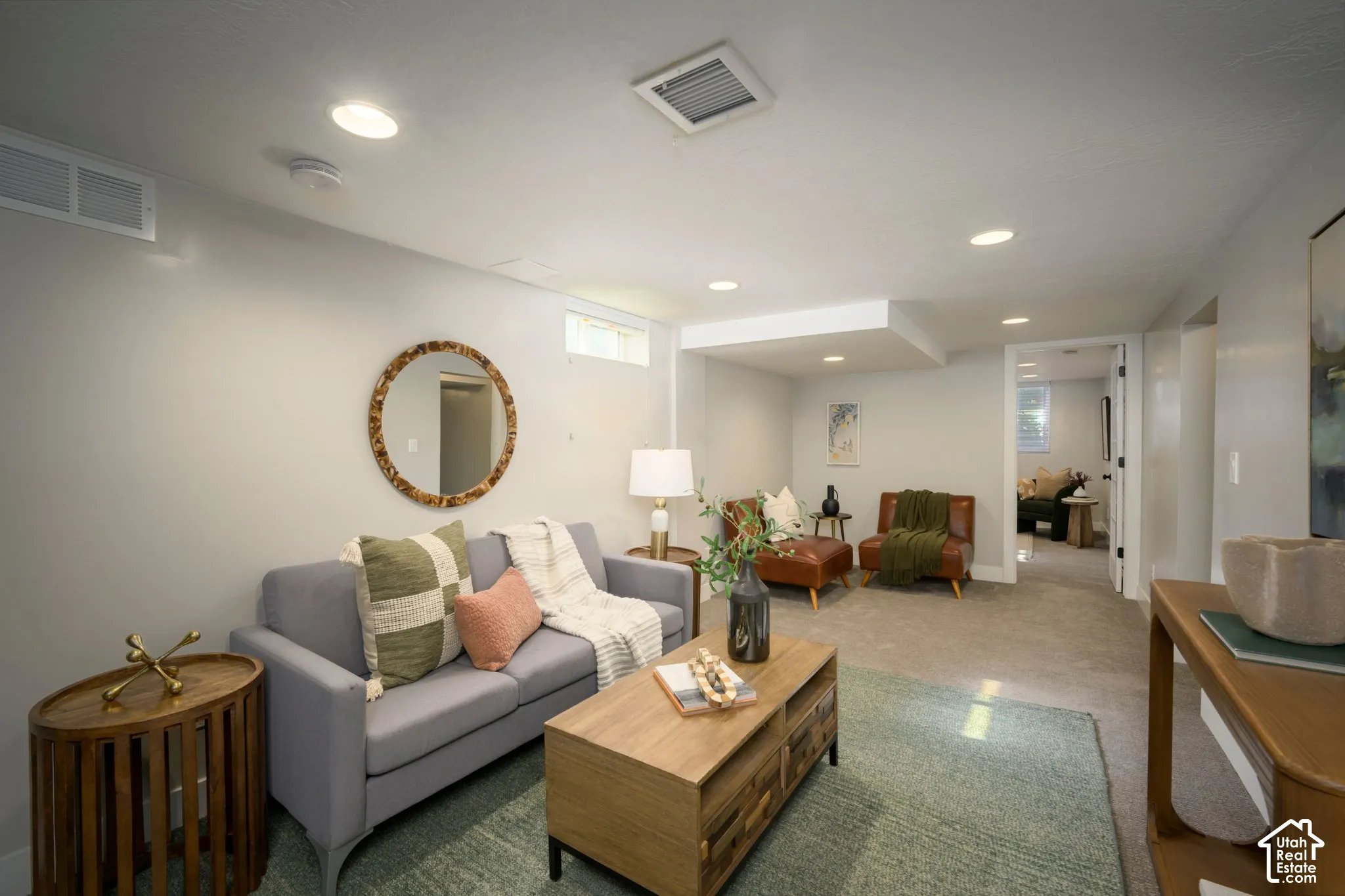Recessed lighting illuminates this carpeted living area with a built-in ceiling soffit