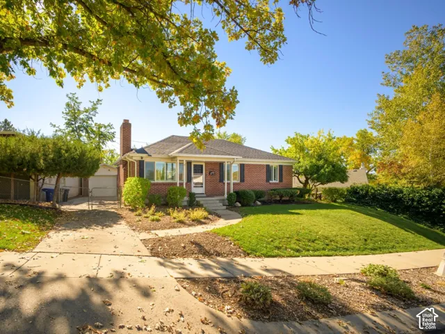 Brick exterior featuring a gabled roofline, covered front porch, and mature landscaping