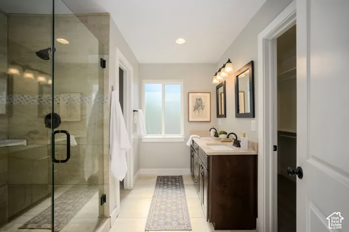 Primary Suite. Glass-enclosed shower with a bench, dual vanity with undermount sinks, and a framed window
