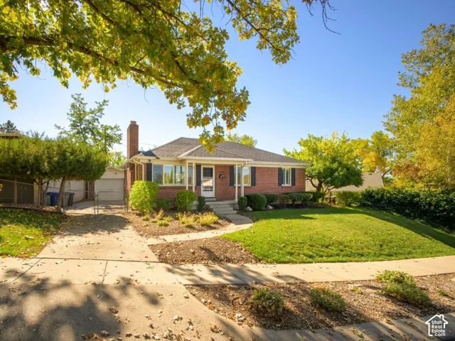 Brick exterior featuring a gabled roofline, front porch, and mature landscaping