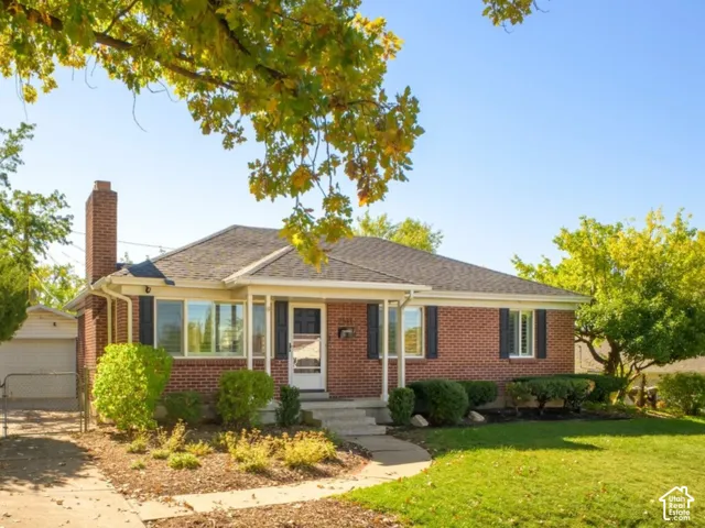Brick exterior with a prominent chimney, a front porch, and dark shutters