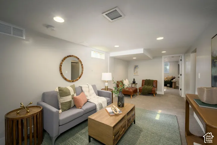 Recessed lighting illuminates this carpeted living area with a built-in ceiling soffit
