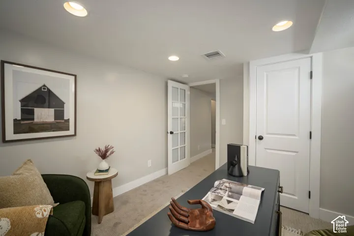 Recessed ceiling lighting, light gray wall paint, white trim, paneled interior door, and French panel door