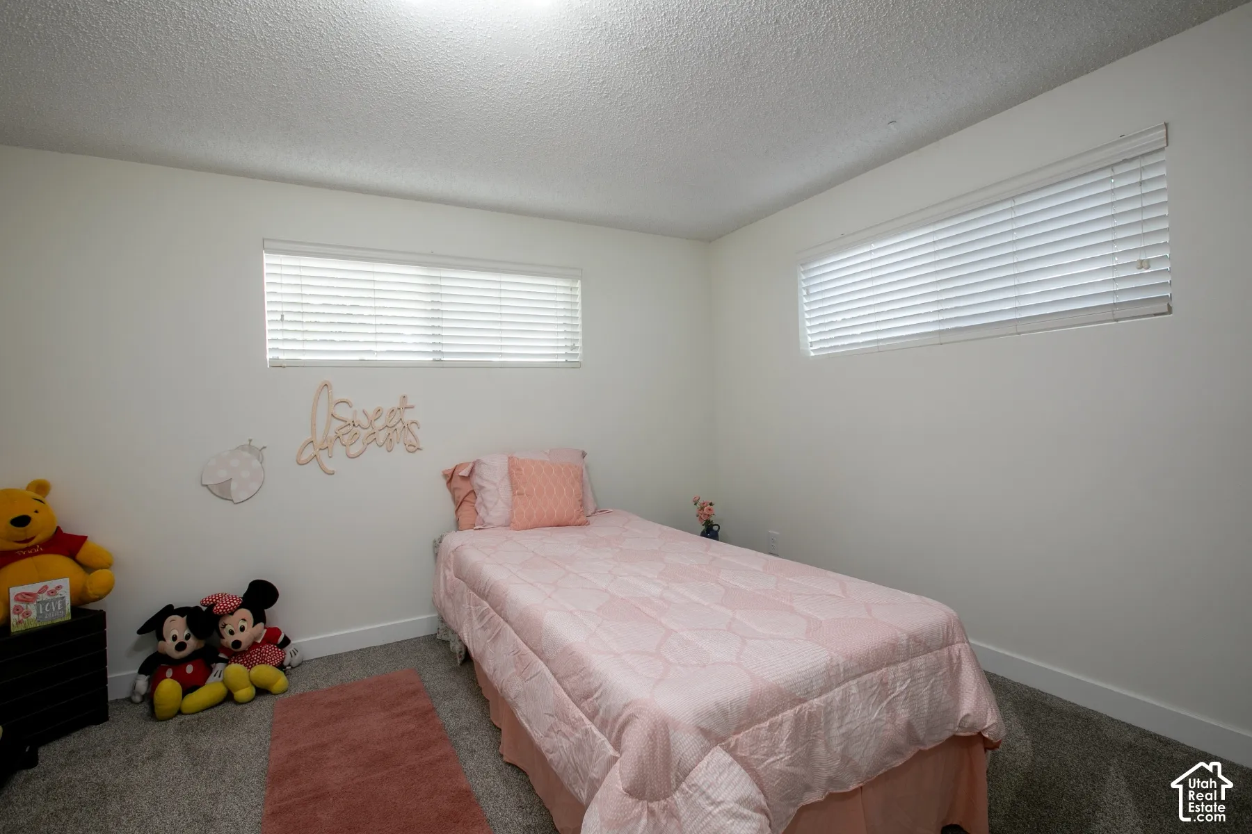 Recessed lighting, light-colored walls, and gray carpeting