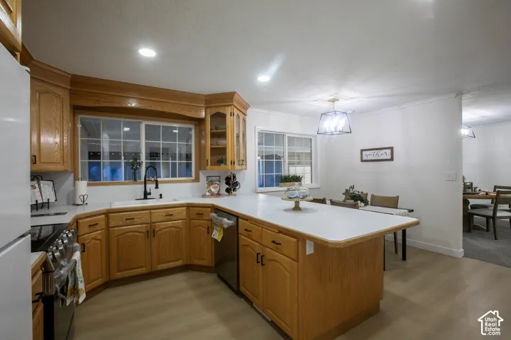 White countertops, wood-finish cabinetry, recessed lighting, and wood-finish flooring