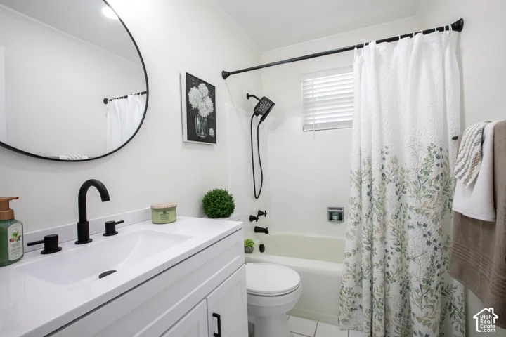 White vanity with integrated sink, matte black faucet, and round framed mirror