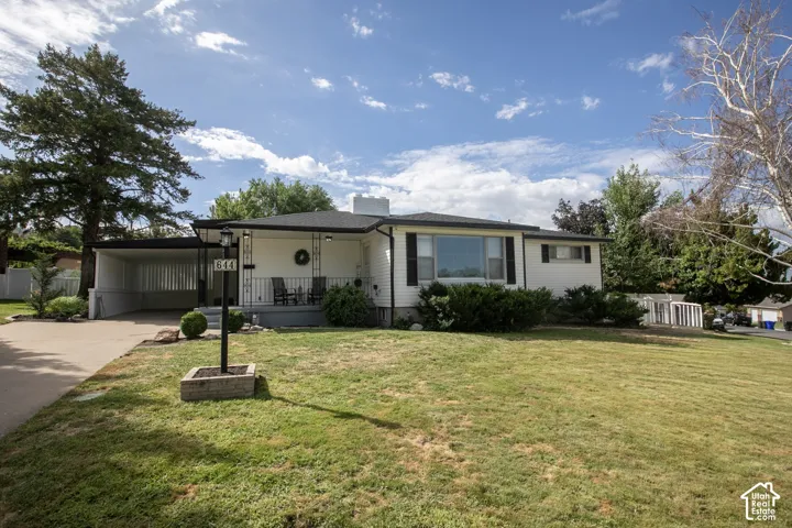Single-story residence featuring a covered front porch, an attached carport, and a prominent bay window