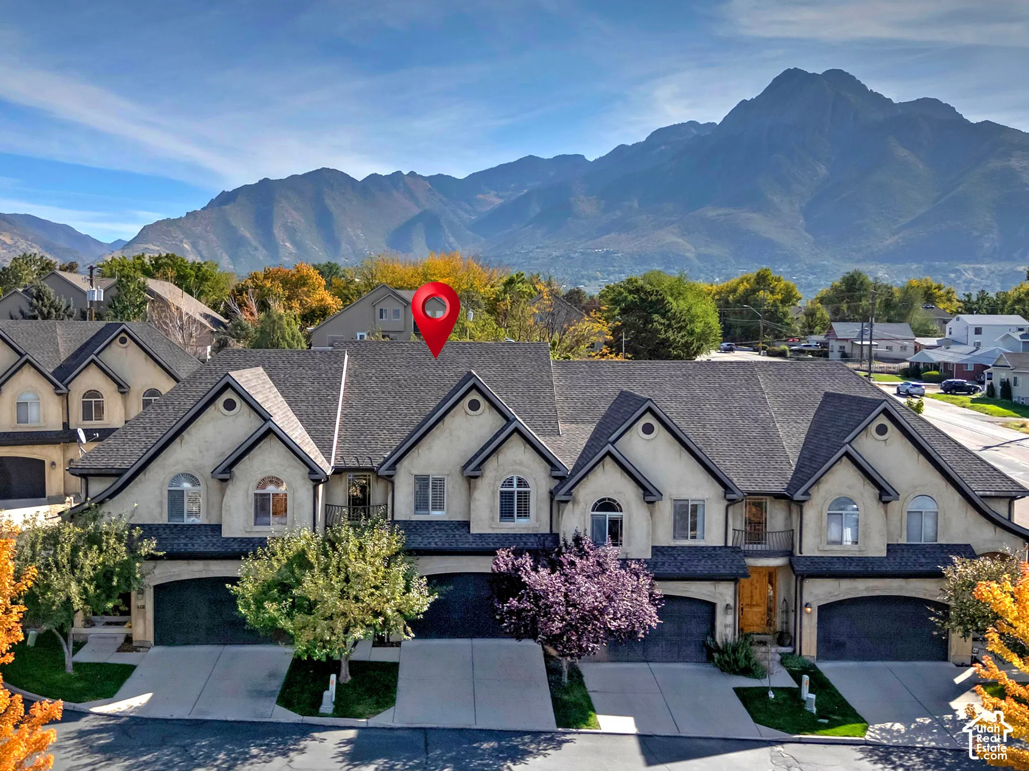 Townhome-style residences with attached garages, stucco exteriors, and sloped roofing