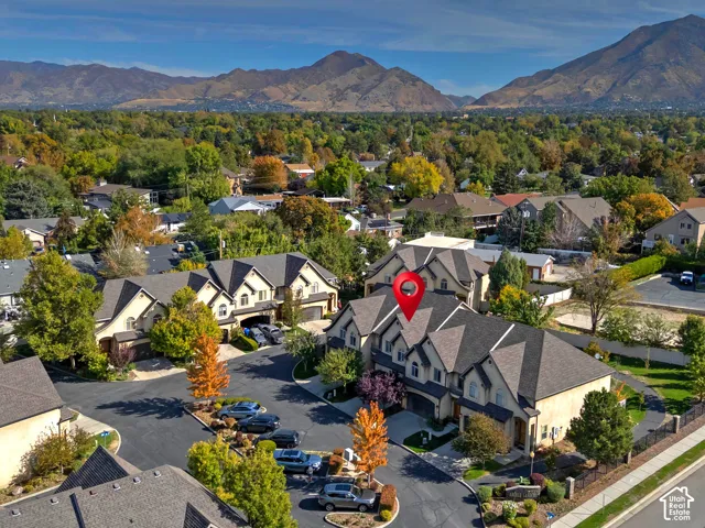 Multi-story residential buildings with gabled roofs, stone and stucco exterior, and attached garages