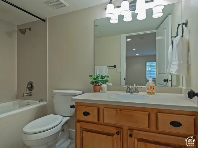 Full bathroom featuring a single vanity with wood cabinetry, a light-colored countertop, and a built-in sink