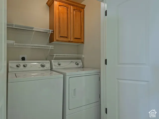 Laundry area featuring overhead wood-finish cabinetry, white wire shelving, and neutral wall paint
