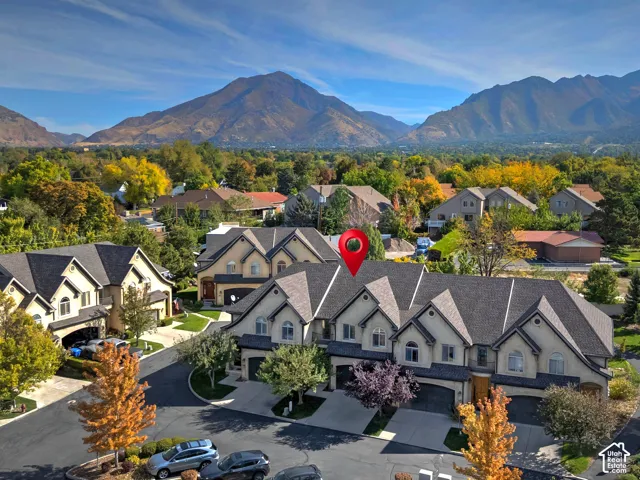Townhome community with mountain scenery, mature trees, and individual garage access