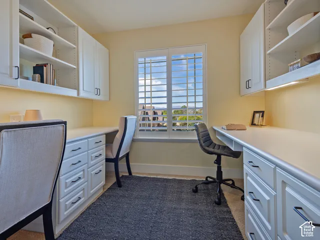 Built-in desk cabinetry featuring white finishes and dark hardware