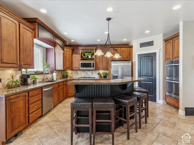 Wood-finish cabinetry paired with a stone countertop and tile backsplash