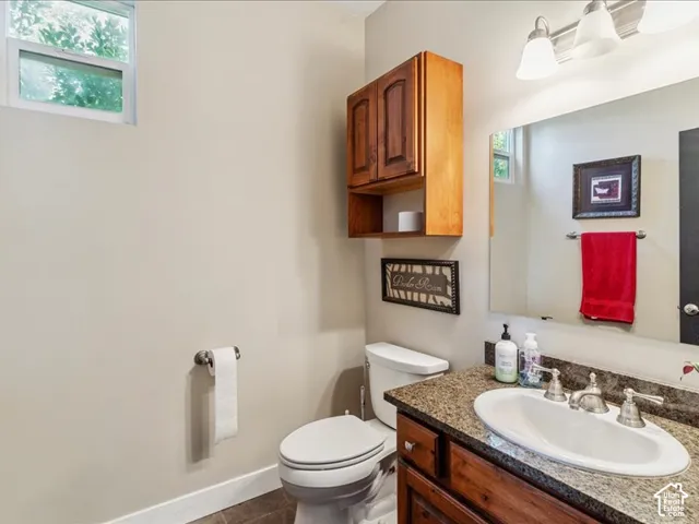 Vanity with a granite countertop, oval undermount sink, and brushed nickel fixtures