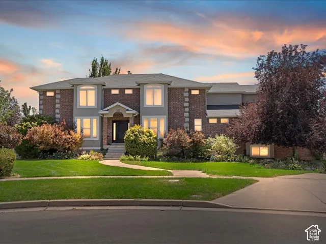 Brick and siding exterior with multiple bay windows, a covered entryway, and a paved driveway
