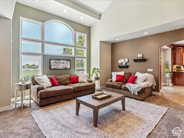 Vaulted ceiling, recessed lighting, and a large arched window array