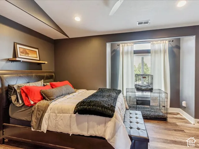 Recessed lighting, wood-finish flooring, and a window with blinds
