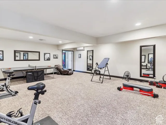 Expansive recreation space featuring light-colored carpeting, recessed lighting, and white walls