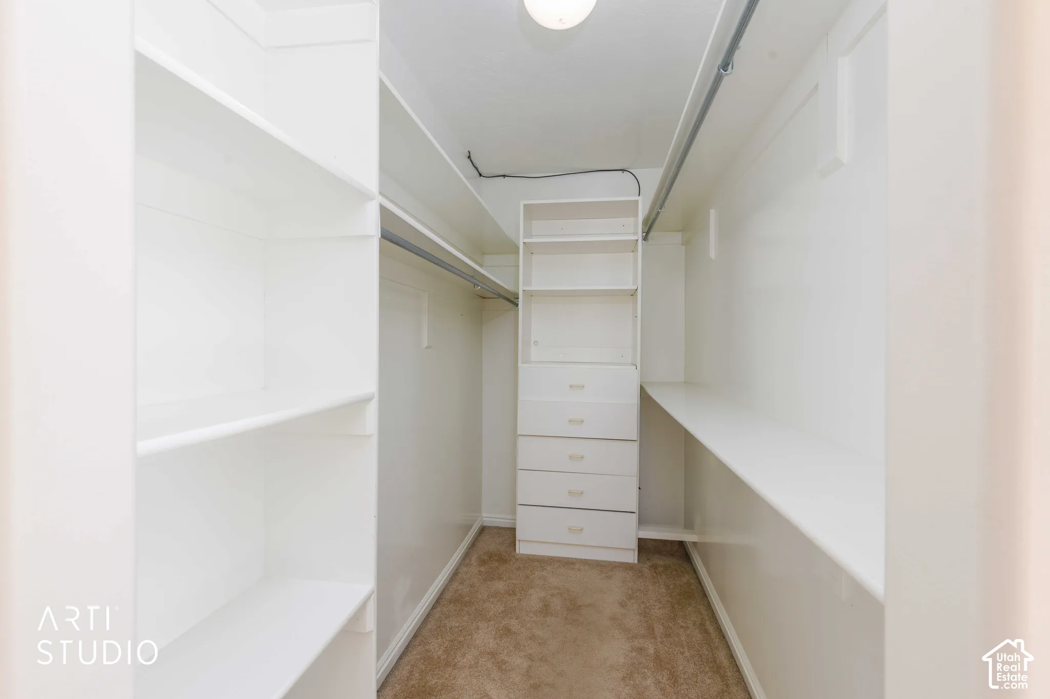 Walk-in closet with built-in shelving, integrated drawers, and ample hanging rods