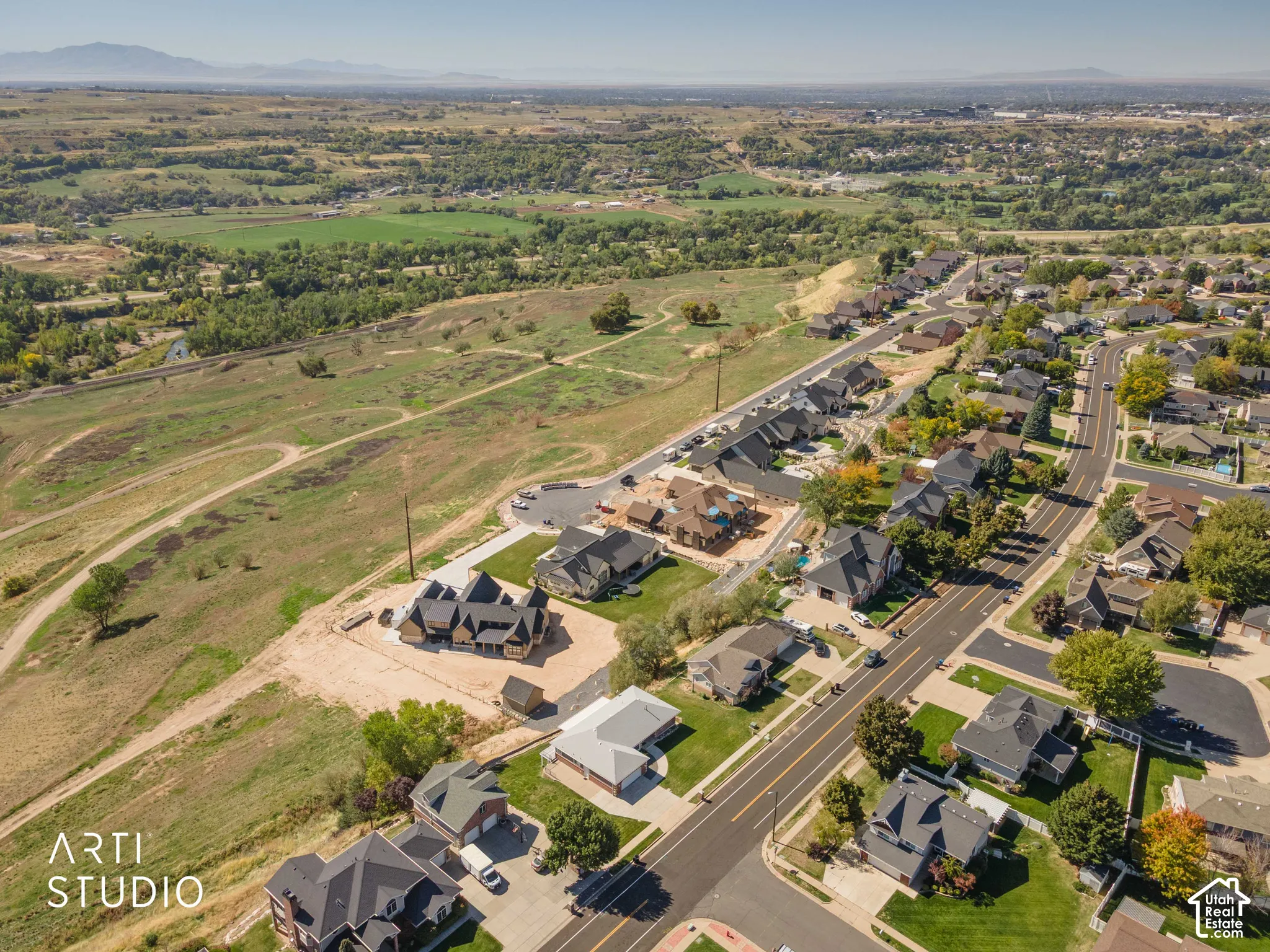 Expansive land features a mix of developed residential areas and undeveloped natural terrain with distant mountain ranges