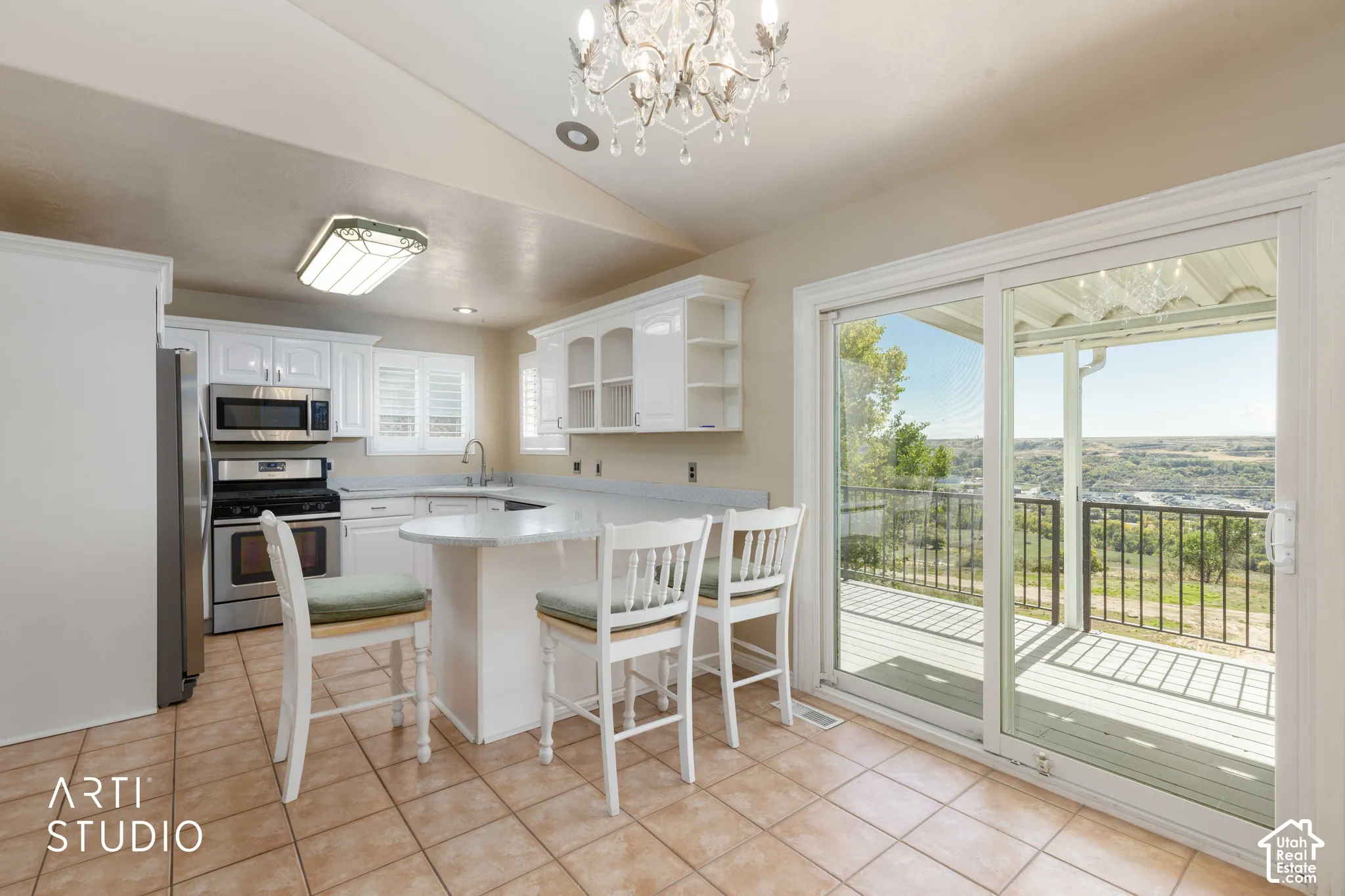 Kitchen with white cabinetry, stainless steel appliances, a breakfast bar, and tile flooring