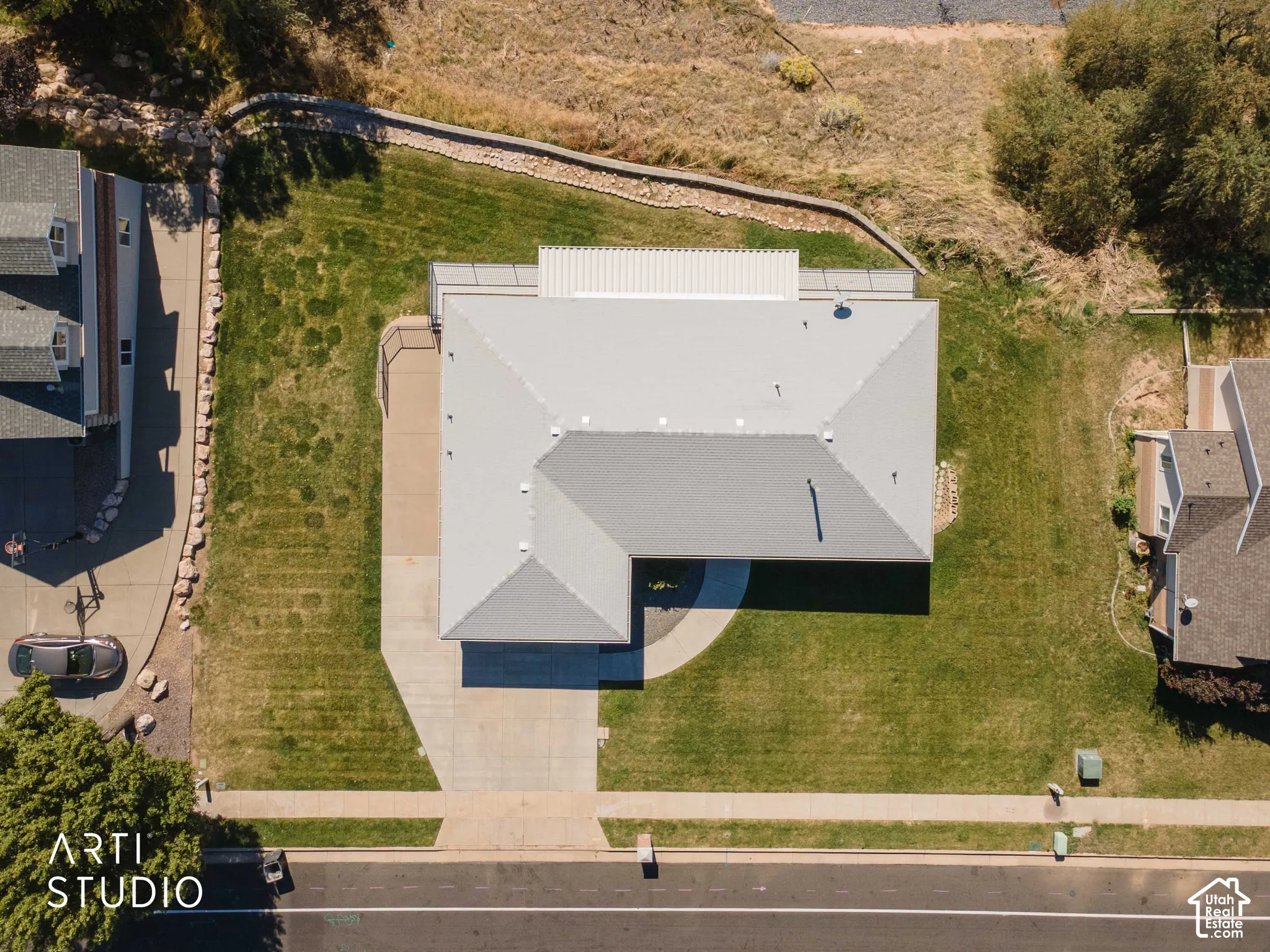 Pitched roof residence featuring an attached garage and concrete driveway
