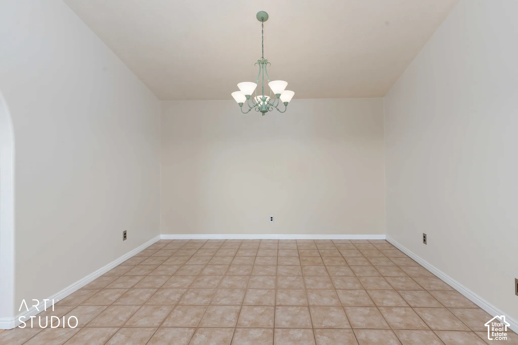 Recessed niche with an arched opening, tile flooring, and a decorative ceiling fixture