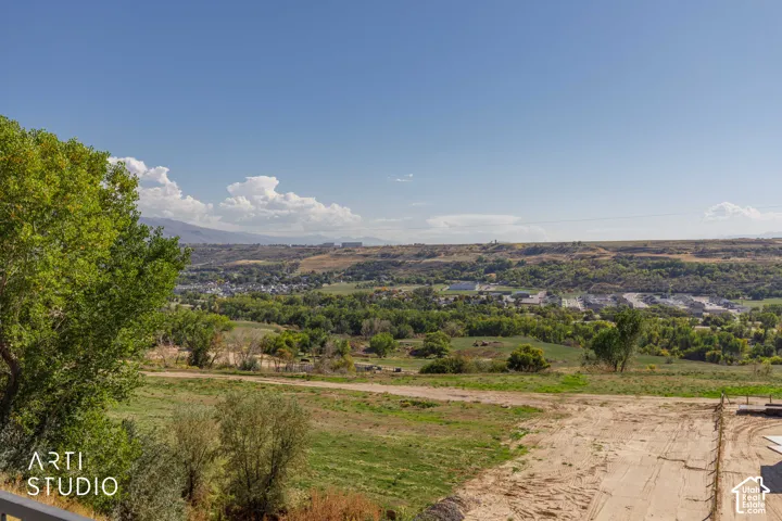 Expansive outdoor setting with varied terrain, distant structures, and a clear sky backdrop