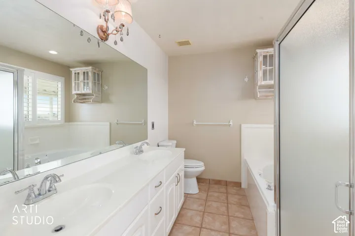 Double vanity with integrated sinks, large wall-mounted mirror, ceramic tile flooring, built-in bathtub, and a separate shower with a frosted glass door