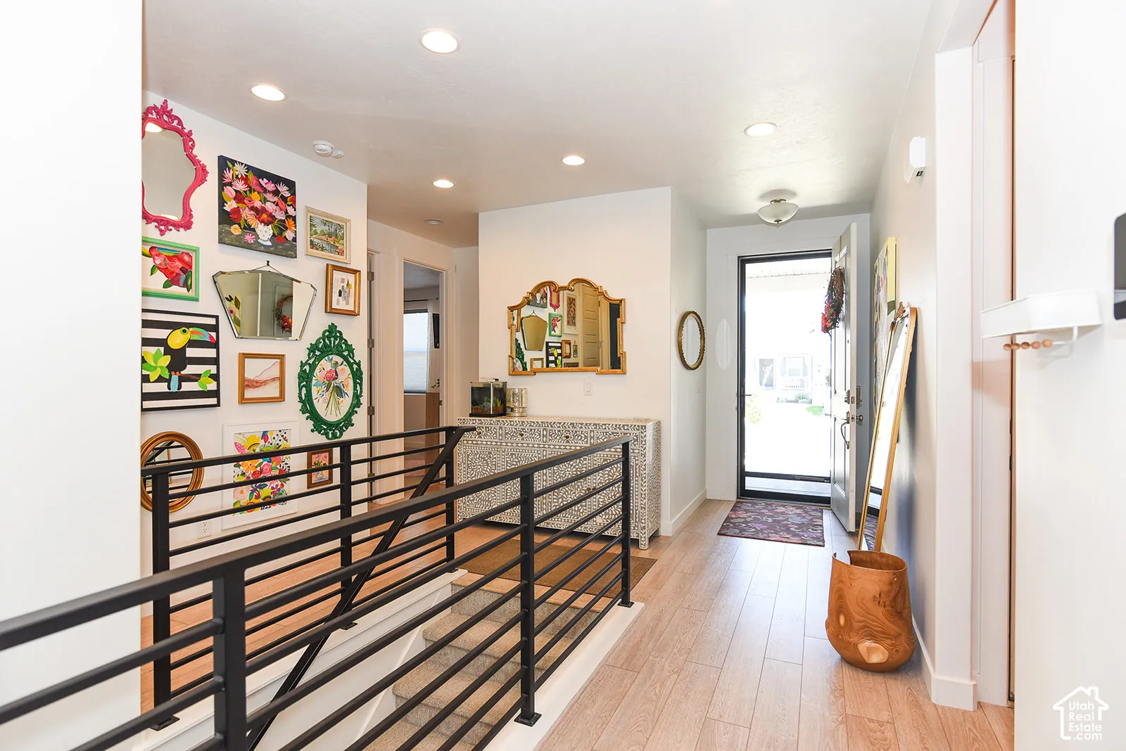 Entryway featuring wood-finish flooring, recessed lighting, and a modern black metal railing