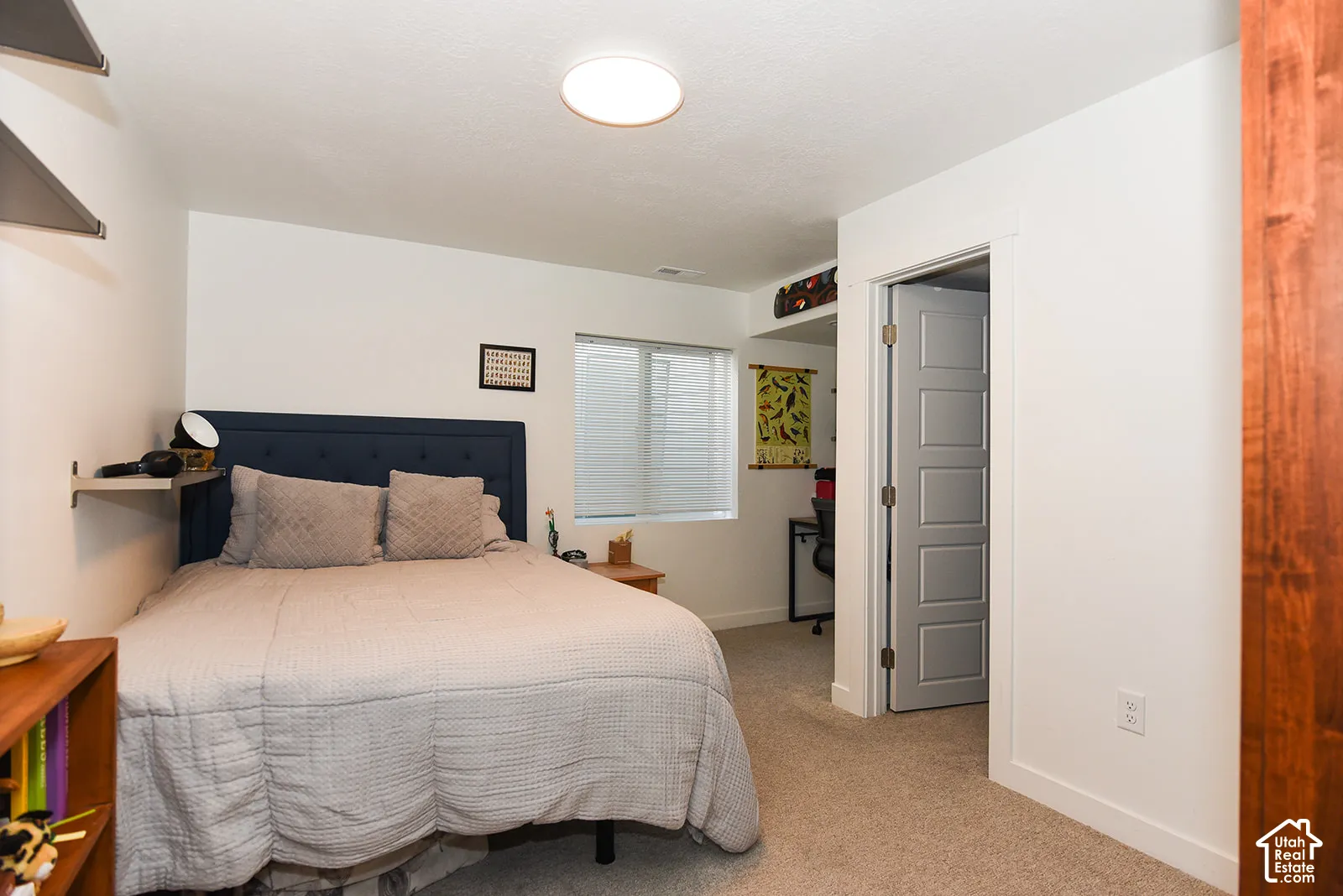 Carpeted room with a flush-mount ceiling light fixture, white walls, and a window with blinds