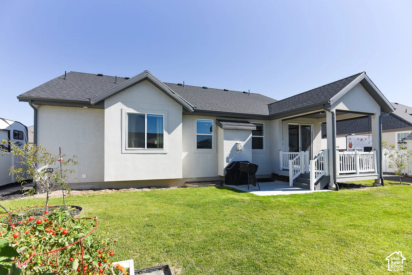 Expansive backyard with a manicured lawn, covered patio, and a separate concrete patio area