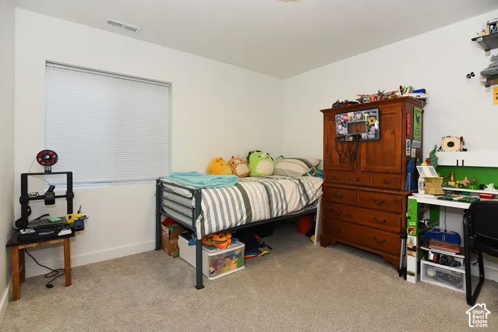 Soft gray carpeting, white walls, and a window with blinds create a neutral backdrop